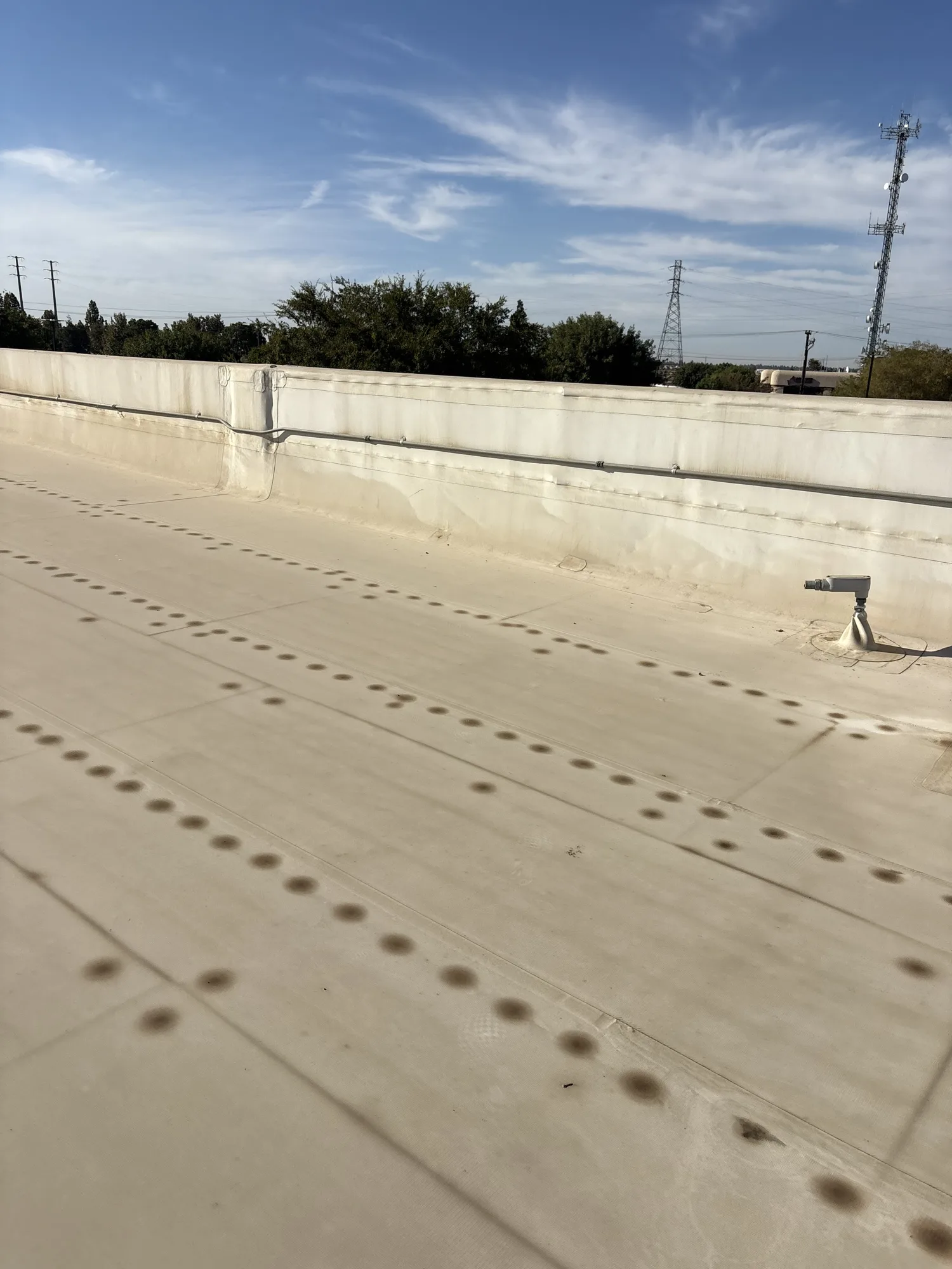 Existing TPO membrane at a commercial roof parapet in Bakersfield